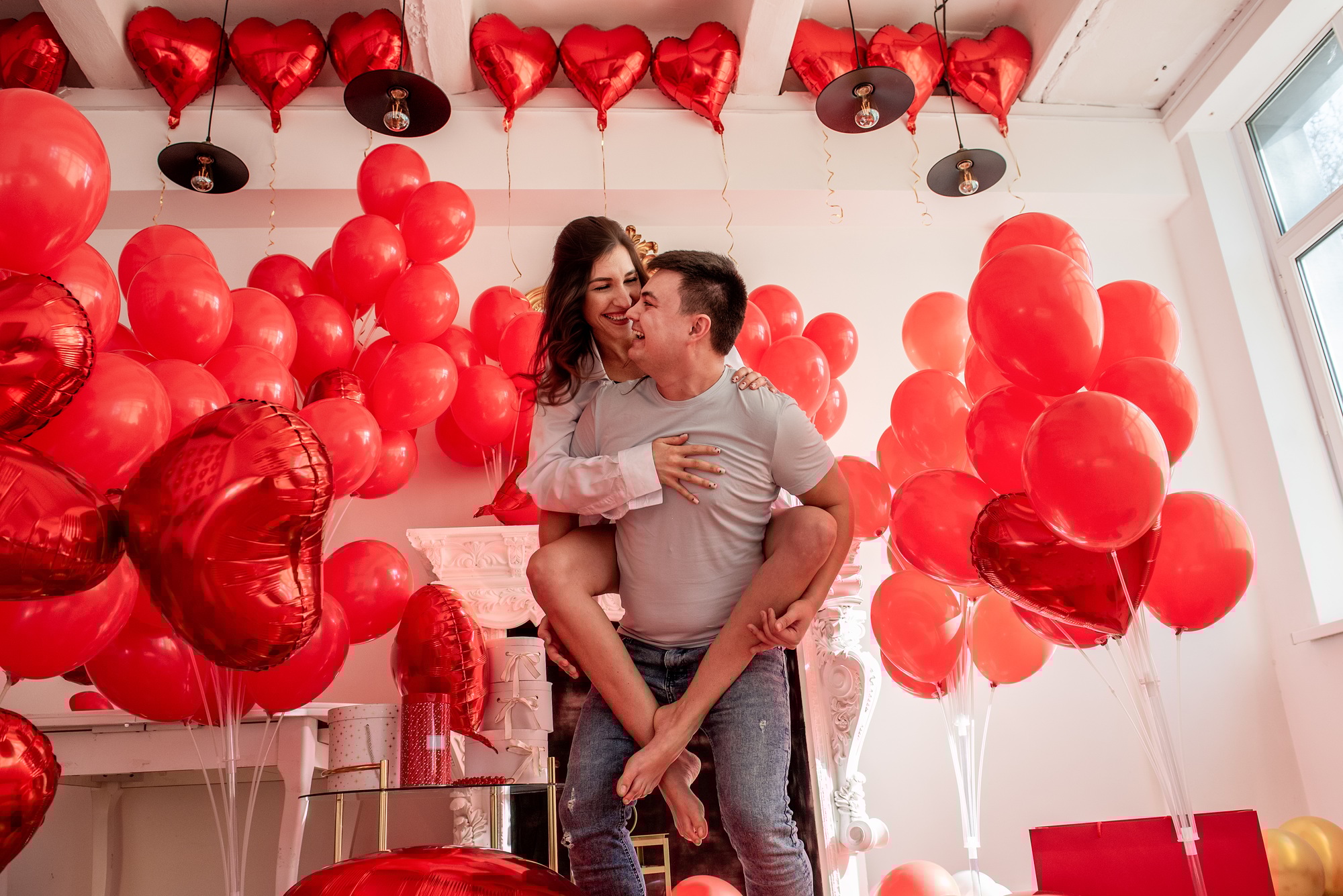 Couple fooling around, looking into each others eyes. Woman sitting on mans back. Valentines day