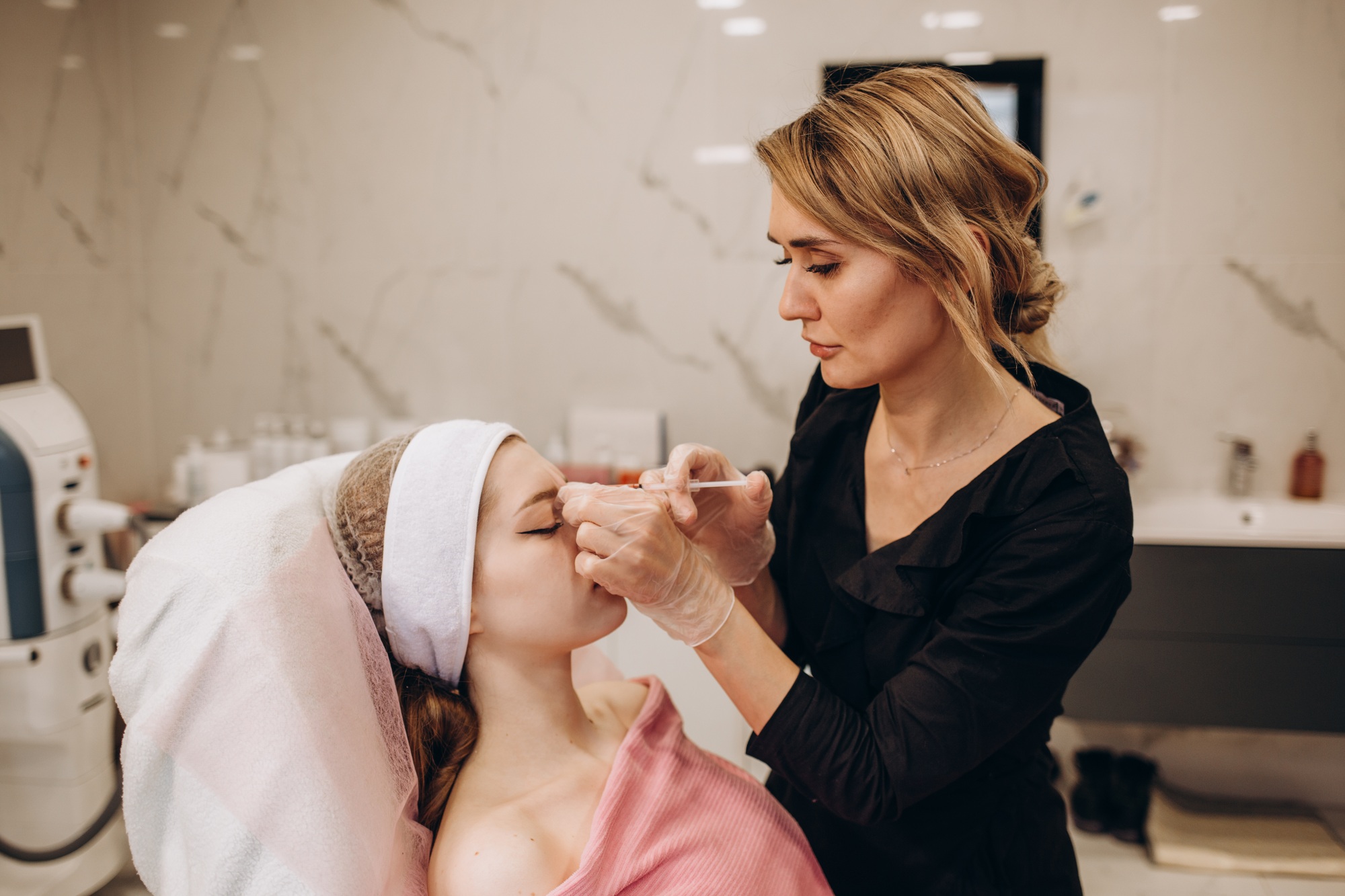 Cosmetologist makes injections on the face. Spa concept relaxation and self-care.